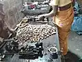 Factory workers engaged in deshelling, scooping, and kernel separation of cashew nuts