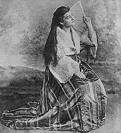Woman in a traje de mestiza with a pañuelo and abanico folding fan (c. 1900)