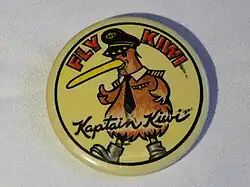 Promotional button for Kiwi International Airlines, circa 1994. Diameter 54mm. Yellow background, with cartoon figure of a Kiwi bird wearing airline captain's hat, tie, wings, and shoulder insignia. Says "FLY WIKI" in red block letters on the top, and "Kaptain Kiwi" in script across the bottom.