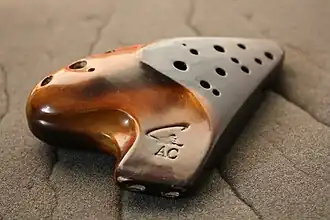 An Asian double chambered ocarina; the two blow holes in the mouthpiece are clearly visible. The separate chambers make possible an extended range of notes (17 in total, in this case from A4 to C6)