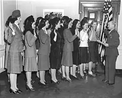 A group of enlisted women being sworn into the Marine Corps during the Second World War, with the oath administered by a male officer