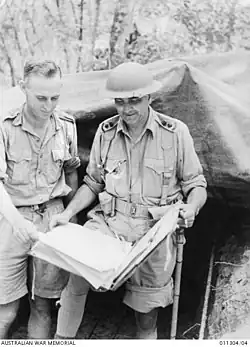 Lieutenant Colonel Frederick Galleghan examining a map with Sergeant Heckendorf outside the command post at Gemas.