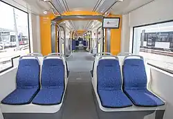 Tram interior with two groups of four seats in back-to-back pairs either side of the aisle