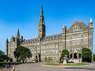 A large Gothic-style stone building dominated by a tall clocktower.