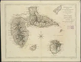 Beige paper with a hand drawn map of Guadeloupe with a compass rose drawn in the center. Below the southwest coast of Basse-Terre Island is the smaller islands of les Saintes, with the Les Saintes Passage labelled in the passage of water in between.