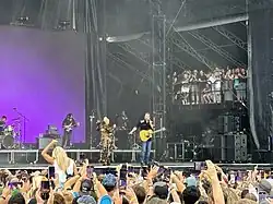 A color picture of singer Gwen Stefani and Blake Shelton performing their song "Purple Irises" live.