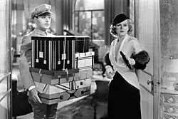 Albert carries an armful of boxes for Lillian