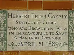 A tablet formed of six standard sized tiles, bordered by green flowers in the style of the Arts and Crafts movement