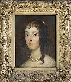 A lady with brown eyes and hair wearing a pearl neckless