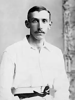 A head and shoulders portrait photograph of Truble wearing cricket whites