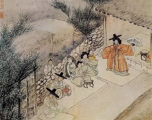 Meeting in a beige setting, the shaman wears orange.