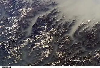 Clouds fill the valleys, but not the mountaintops. From the ISS in June 2006.