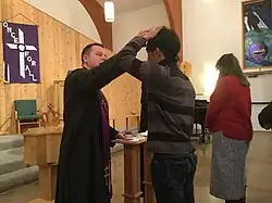 A Lutheran pastor distributes ashes to a communicant during a Divine Service, 2017.