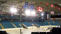 Interior view of ice hockey rink surrounded by seats coloured blue