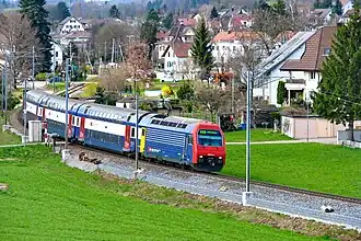 Red-and-blue locomotive pulling double-decker coaches