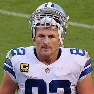 Headshot of Jason Witten on a football field in uniform with his helmet resting on top of his head