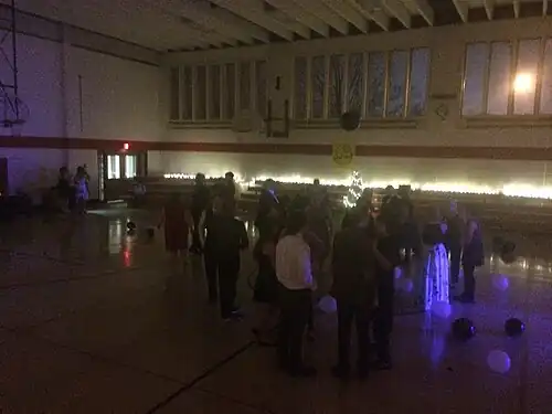 This photo is one of the only known representations of the dance itself and highlights the multiple issues the school faced at the Harvey Street Location, including limited space, inability to customize the space with school colors and branding, and a lackluster event space which was often commandeered by the diocese.