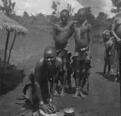 Gusii women grinding millet while other natives watch c. 1916–1938