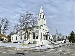 Brick building with white columns and "Village Hall" signage