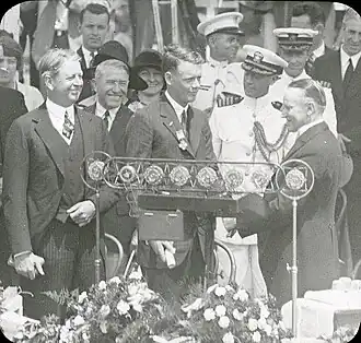 Lindbergh looks on as President Calvin Coolidge presents her son with the Distinguished Flying Cross (June&nbsp;11,&nbsp;1927)
