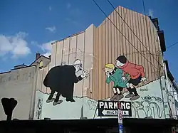 Color photograph of a mural showing the Quick and Flupke characters in the streets of Brussels.