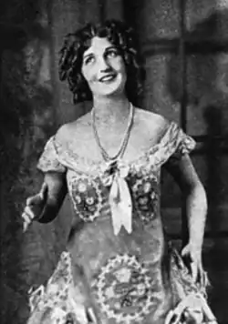 Louise Hunter, smiling, in a light-colored beaded gown, from a 1929 publication