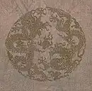 Opposing dragons (one ascending and one descending) chasing after flaming pearl enclosed in a roundel