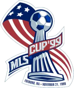Match logo, featuring the league trophy—a soccer ball on a curved pedestal—surrounded by a simplified American flag with the text "MLS Cup '99".