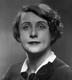 A white woman with bobbed curly hair