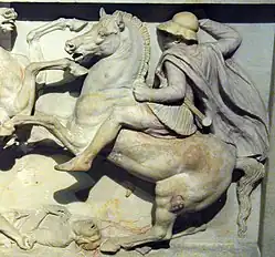 A color photograph of a stone carving, showing a soldier on horseback figjting another soldier not visible in the frame