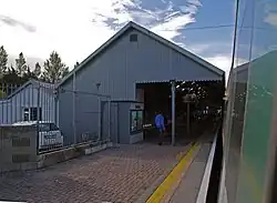 Side view of Mallow railway station's main building from the perspective of an arriving train