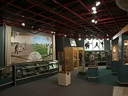 Collections of baseball photos, trophies and equipment in display cases