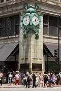 The "Great Clock" on the corner of the Marshall Field & Company Building of 1891–1892, above a crowd of pedestrians at North State and Washington Streets, erected 1897