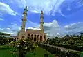 Mosque compound with blooming yellow allamanda plants