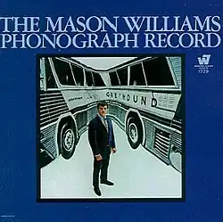 Mason Williams in front of a photograph of a Greyhound bus