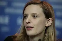 A woman with shoulder-length hair looking off-camera