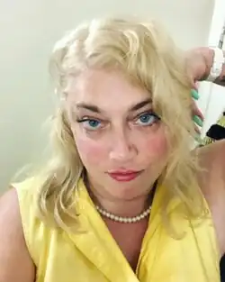 Selfie of Mira Bellwether. She is wearing makeup and a yellow dress.