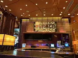 A small indoor restaurant building with a large logo and several lights above.