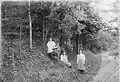 Members of the Montgomerie family under a flowering Laburnum tree within the Dalmore House gardens
