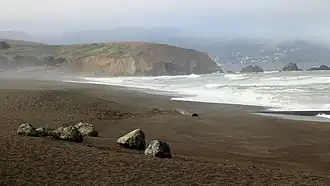 Mori Point is a prominent bluff extending into the Pacific Ocean, seen from a viewpoint looking south from Pacifica Beach.