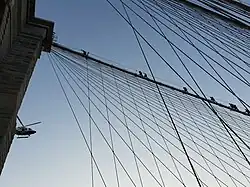 NYPD officers take part in a training exercise on the Brooklyn Bridge by climbing a large cable leading to a pillar. Under the supervision of a helicopter.