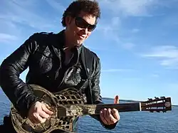 Ned Evett with his trademark fretless mirrored-glass and steel resonator, the "Globro"