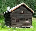 "Nestegardstugu fra Nestegard i Hovet" - This loft house from Nestegard in Hovet was built in the beginning of the 18th century as a living room and guest room with sleeping loft upstairs. It has 2 floors, built in timber and with peat roofs. The first floor is a 3-room stugu with hallway, stugu and stick. Roofs, walls, cabinets and bed are painted in the Rosemåling style by Kittil Rygg in 1759. The house was moved along with the Nestegard farm in 1751, and brought to the museum in 1936.[22]