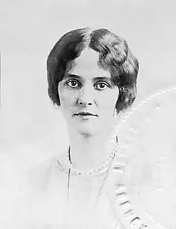 A cropped passport photograph of newlywed Ginevra King circa 1918 in a frontal pose, looking directly at the camera. Her hair is styled in a short bob, and she is wearing a light-colored blouse with a pearl necklace.