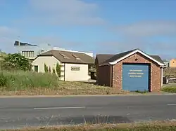 Observatory to rear in elevated position above public toilets and Coastguard building on coast road
