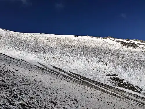 Tooth-like snow forms on a medium-steep slope of a mountain
