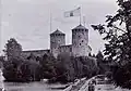 Olavinlinna in Savonlinna, Finland, from around the year 1875. In the castle's flag pole is hosten an unofficial flag Russian Empire as well as the coat of arms of the Grand Duchy of Finland.