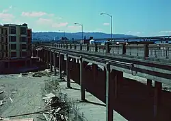 A car and two bicyclists going across a viaduct