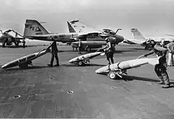 An A-6E TRAM Intruder (NF-506) from VA-115 and an F/A-18A Hornet (NF-106) from VFA-195 taxi to a catapult during the Gulf War.