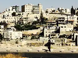 Member of the ultra-Orthodox Jewish community walking in front of Silwan. Many members of the ultra-Orthodox community travel to and live in Jerusalem